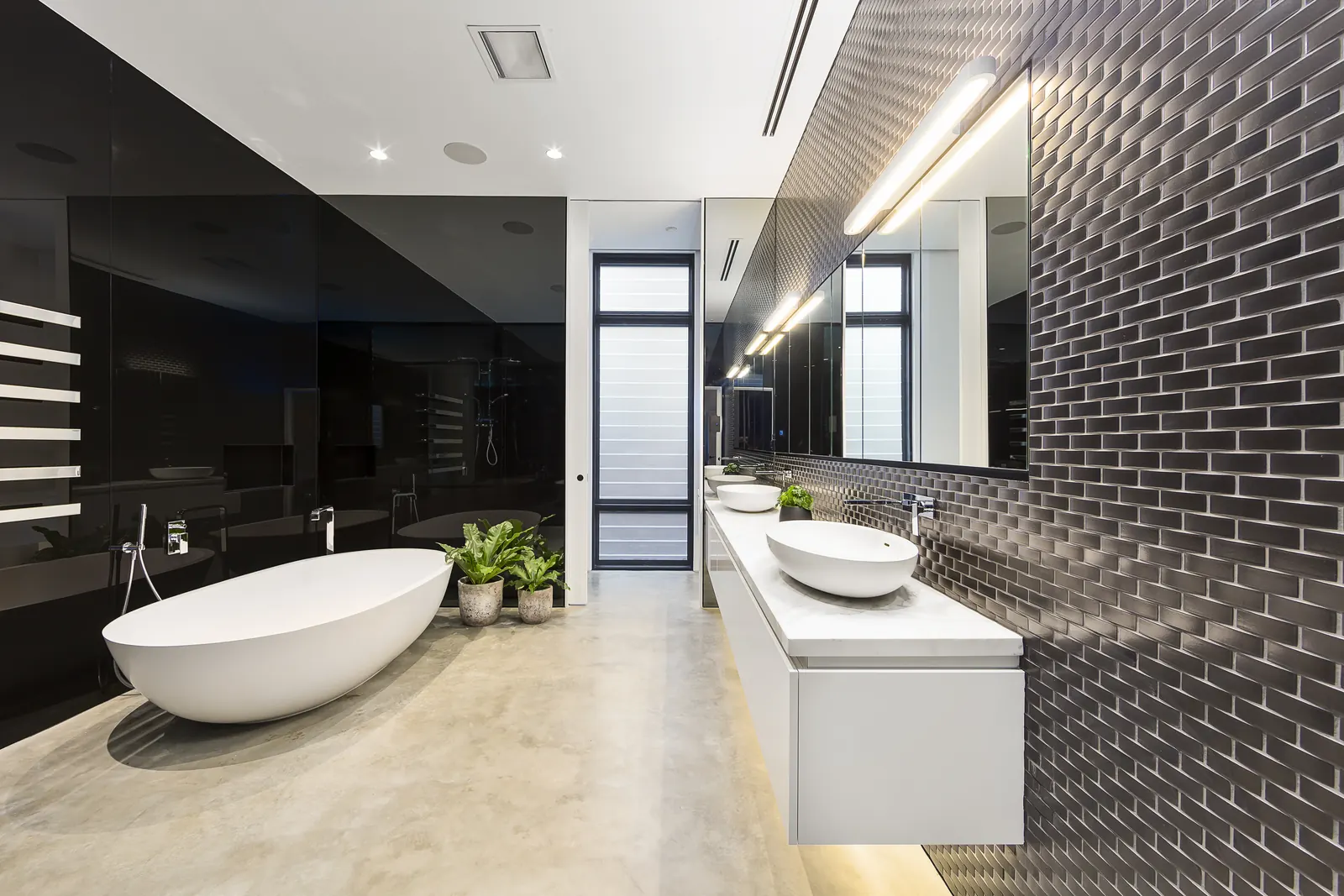 Black subway-tile feature wall with a floating vanity