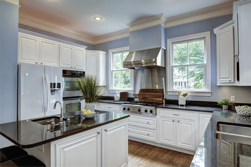 Painted cabinets, black granite counters and a stainless range hood