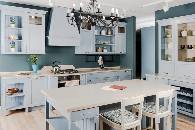 Teal accent wall with white cabinetry and a chandelier