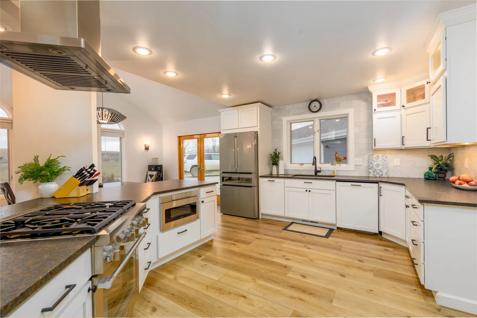 Open kitchen with maple floors and an under-window sink