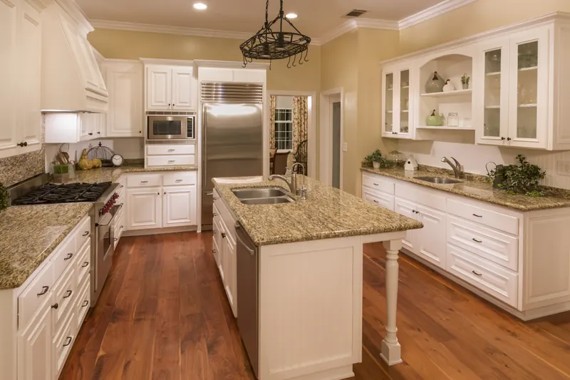 Galley-style island with granite tops and glass-front uppers